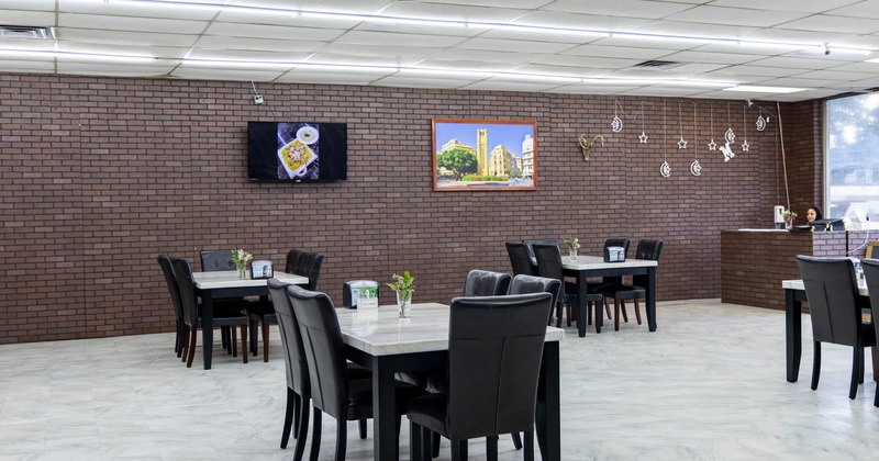 Interior, tables ready for guests,  a TV and a picture on the wall