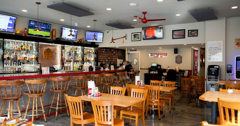 Interior, wooden tables and chairs, bar on the left