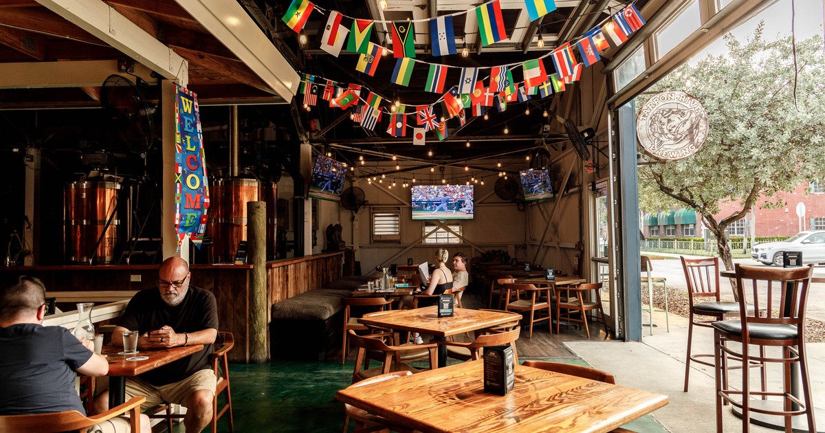 Interior of a lively brewery featuring wooden tables