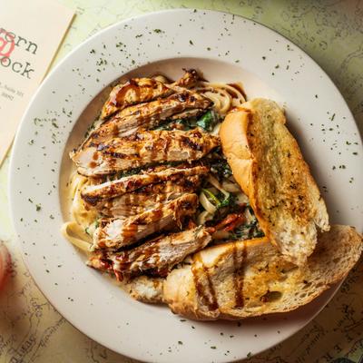 Fettuccine pasta with chicken and side bread.
