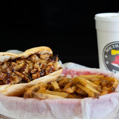 Grilled chicken sandwich with fries and a drink.