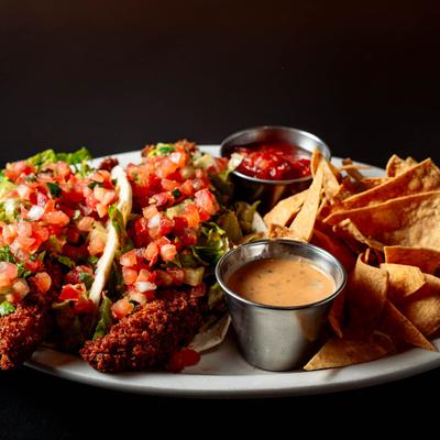Tacos, with panko crusted haddock, lettuce, pico de gallo, chipotle dressing, salsa, and chips.