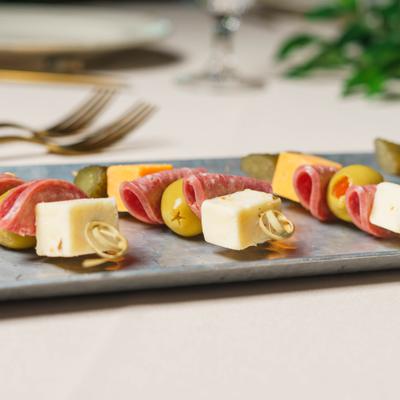 Antipasto skewers made with cubes of cheese, folded salami, and green olives.