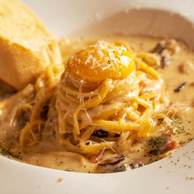 Creamy pasta dish with grated cheese, egg yolk, and bread.