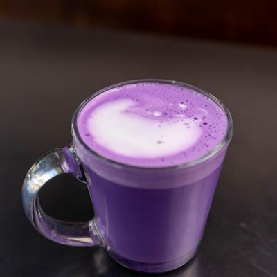 Ube Latte served in a glass cup.