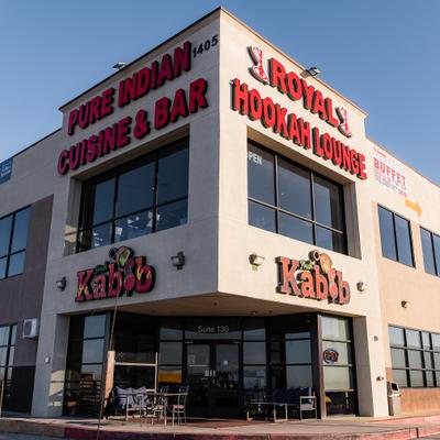 Exxterior, storefront with outdoor seating area, entrance and signs.