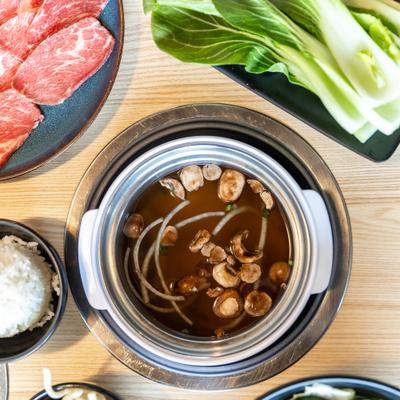Mushroom and onion broth, salad, sliced meat, white rice, top view.
