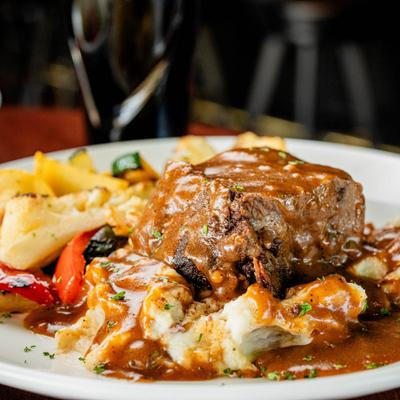 Wine-braised short ribs with mashed potatoes and vegetables.