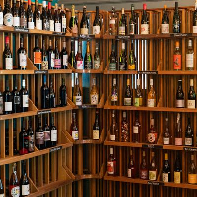Assorted wine bottles displayed on a wooden rack.