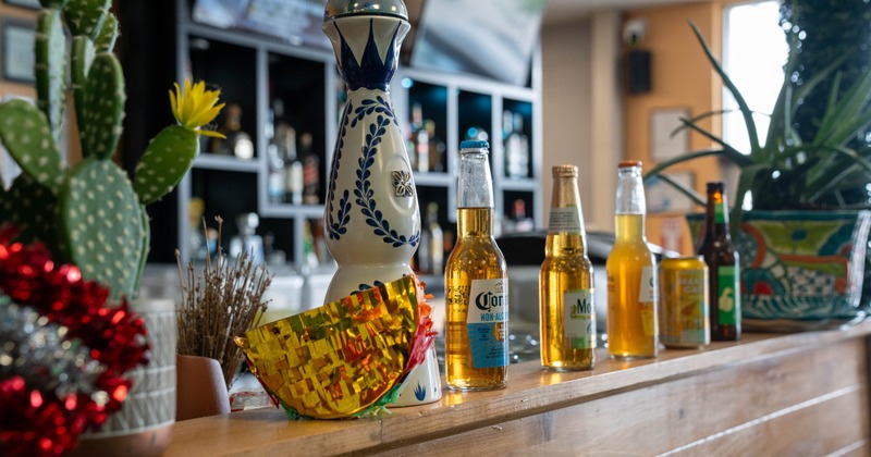 Selection of bottled beer lined on the counter with a bottle of tequila