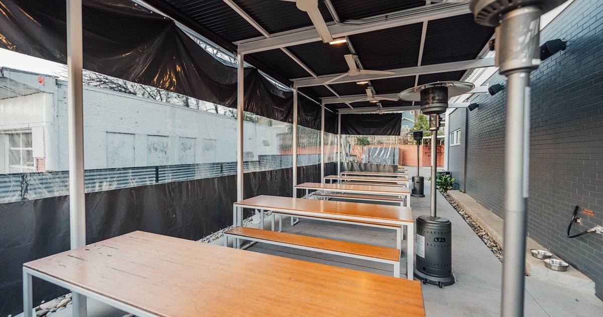 Exterior, covered seating area, large tables with benches, space heaters, ceiling fans