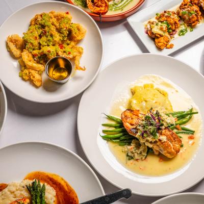 White plates with assorted dishes spread on a white tablecloth.