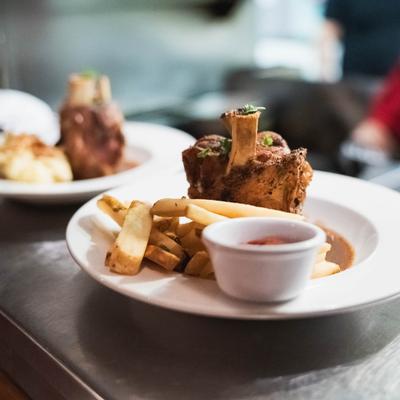 Pork shank with fries and ketchup.