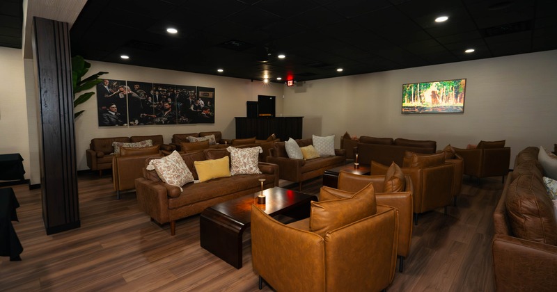 Cozy lounge with brown leather couches and armchairs