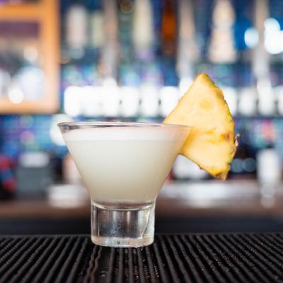Loco Lolo Martini, garnished with a pineapple wedge, placed on a bar counter.