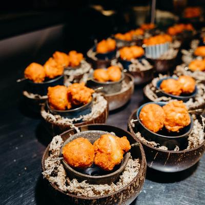 Crispy fried balls served in small dark bowls.