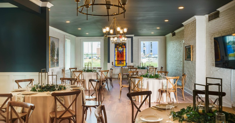 Interior, dining area, round tables with wooden chairs, set up and ready for guests