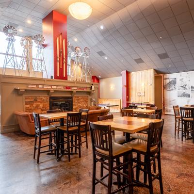 Restaurant interior with high ceilings, fireplace, and wooden tables.