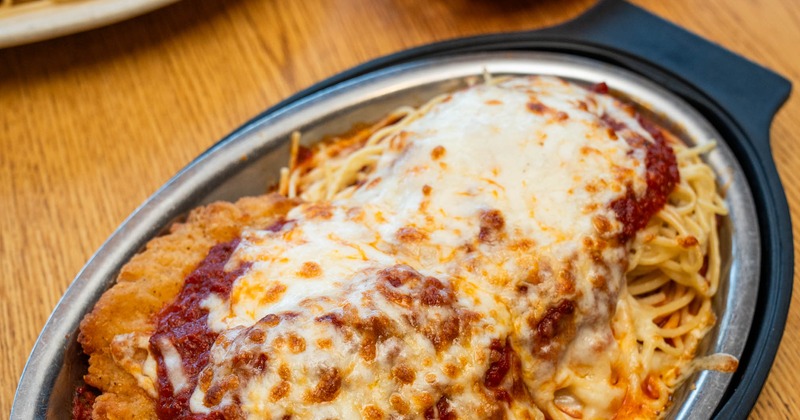 Chicken Breast Parmesan served on a bed of spaghetti