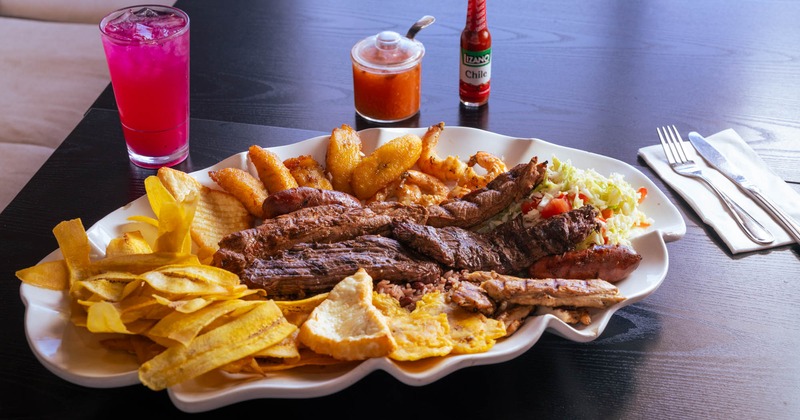 Mixed grill platter with fried plantains and plantain chips