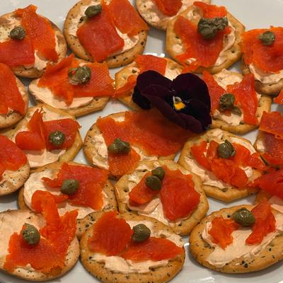 Crackers with smoked salmon, cream cheese, and capers.