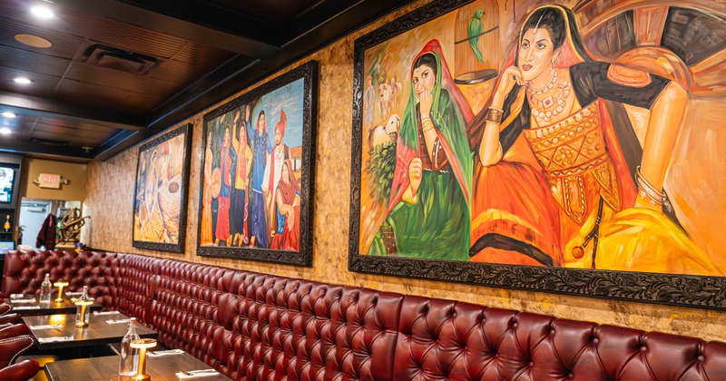 Interior, dining area, large banquette bench with tables and chairs, large format paintings