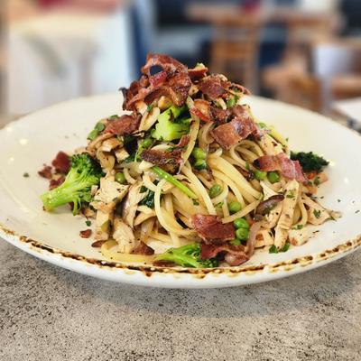 Pasta mixed with broccoli and crispy bacon pieces.