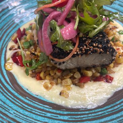 Sesame-crusted tuna steak served over a bed of corn succotash.