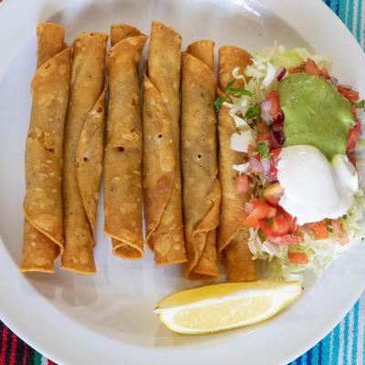 Flautas, served with lettuce, pico de gallo, and sour cream.