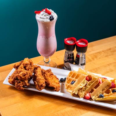 Fried chicken and waffles served with berries, accompanied with a berry shake.