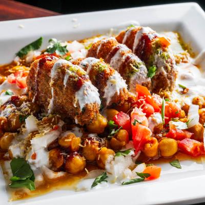 Indian fried mashed potato patties with chickpeas, chutneys, and yogurt.