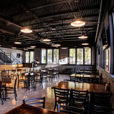 Interior with exposed black ceilings and dark wooden tables and chairs.