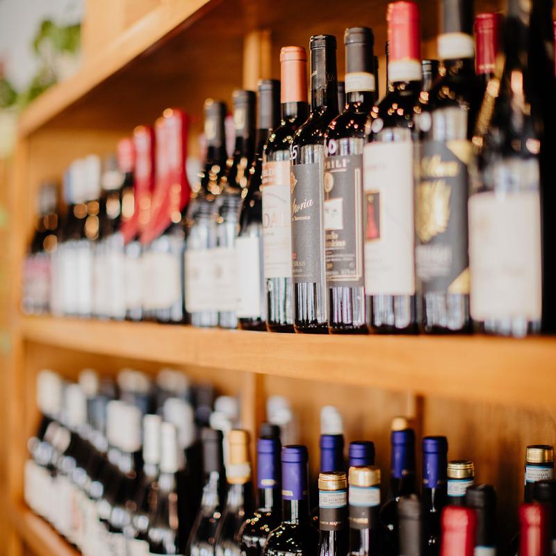 Various bottles of wine displayed on a wooden shelves.