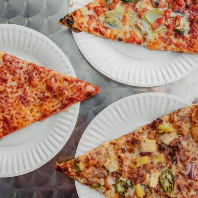 Plates with pizza slices, top view.