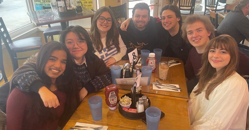 Seating area and order counter with yellow walls covered with framed photos and music posters