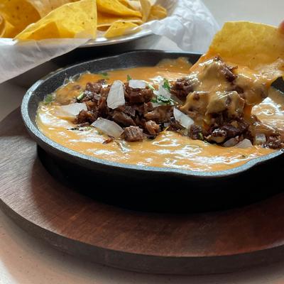 Cheese steak dip with tortilla chips.
