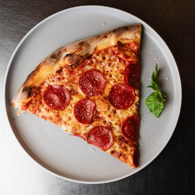 A slice of pepperoni pizza on a white plate.