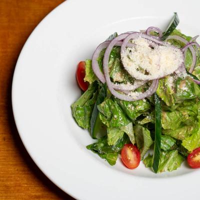 House salad, with lettuce, tomatoes, cucumber, red onion, and parmesan.