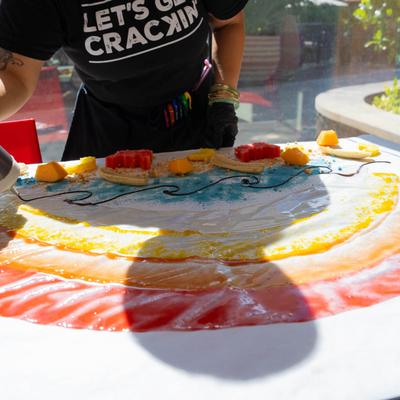 An employee creates a picture on a table using some sweet edible materials.