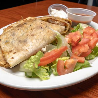 Chicken quesadillas, served with salad, sour cream, and salsa.