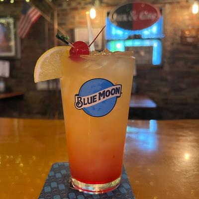 A glass of cocktail with cherry on top