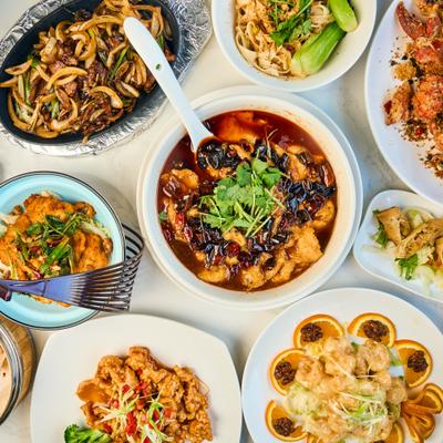Assorted Chinese dishes served across a dining table, overhead view.