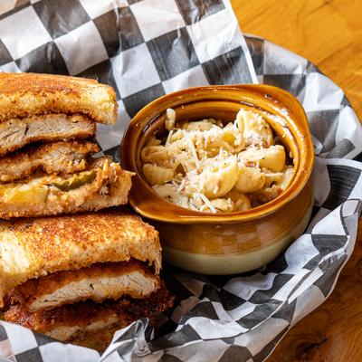 Nashville fried chicken sandwich served with a side of pasta topped with cheese.