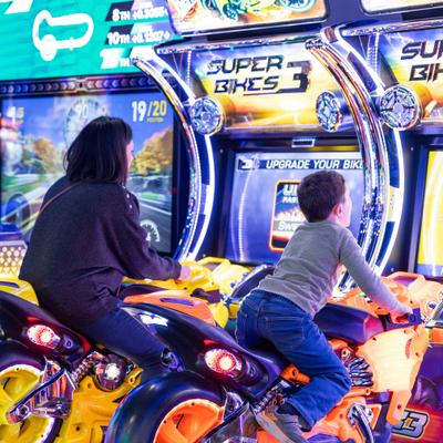 A grown up and a kid at the arcade.