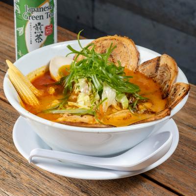 Spicy Miso Ramen topped with stir-fried veggies, baby corn, a half egg and spicy pork belly chashu.