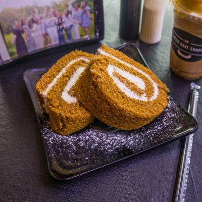 Two slices of Pumpkin Roll dusted with powdered sugar and served on a plate.