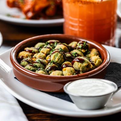 Fried Castelvetrano Olives served with ricotta ranch, displayed with other dishes.