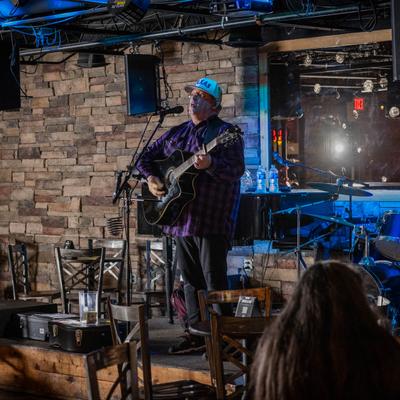 A guitarist performing on a stage inside.