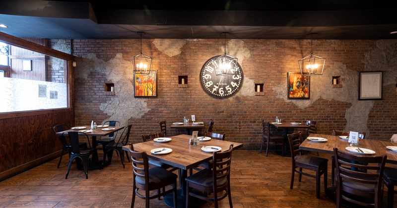 Order counter and set dining area, brick walls decorated with mirrors and paintings