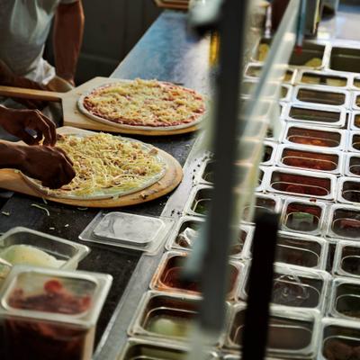 Staff members preparing pizza